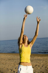 Junge Frau am Strand, die Ball spielt - WESTF01777