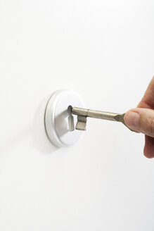 Hand putting key in keyhole, close-up - 04821CS-U