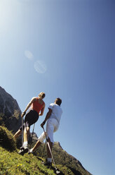 Couple practising nordic walking in mountains, rear view - HHF00444