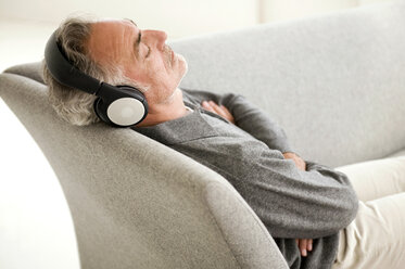 Mature man wearing headphones, eyes closed, elevated view - WESTF01946
