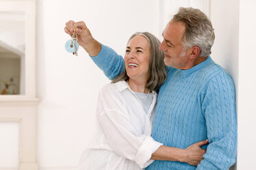 Mature couple smiling, man showing key, close-up - WESTF01896