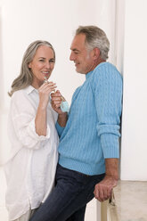 Mature couple holding key, smiling - WESTF01892