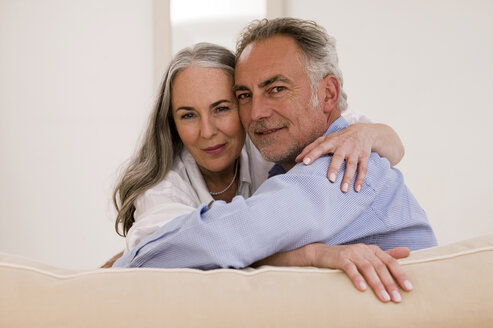 Mature couple embracing on sofa, close-up, portrait - WESTF01887