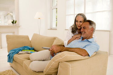 Älteres Paar sitzt auf dem Sofa und sieht fern, Seitenansicht - WESTF01873