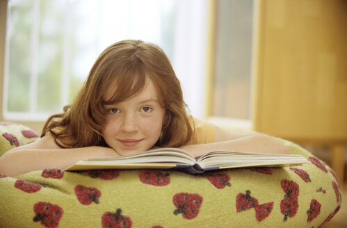 Girl (8-9) reading book, close-up, portrait - NHF00234