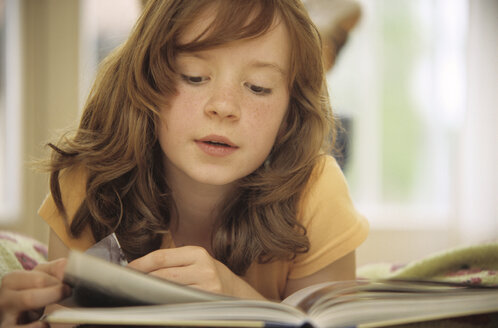 Girl (8-9) reading book, close-up - NHF00232