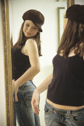 Young woman looking in mirror, close-up - NHF00219