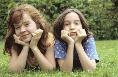 Children lying in meadow in garden, portrait - NHF00213