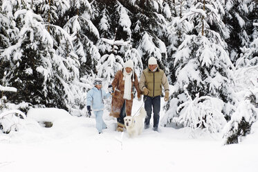 Österreich, Salzburger Land, Eltern und Sohn (6-7) wandern im Schnee mit Hund - HHF00720