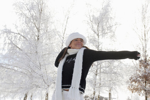 Junge Frau im Schnee, sich streckend - HHF00683