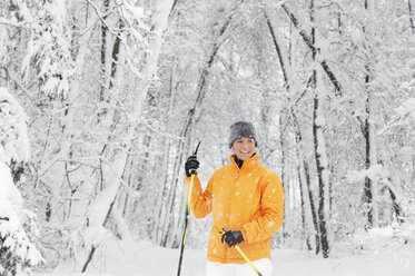 Junge Frau im Schnee mit Skistöcken - HHF00674