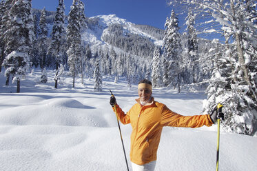 Young woman in snow holding ski sticks - HHF00671