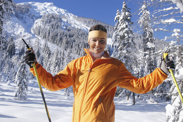 Junge Frau im Schnee mit Skistöcken - HHF00670