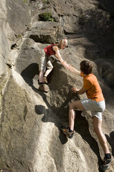 Young couple rock climbing, low angle view - WESTF02365