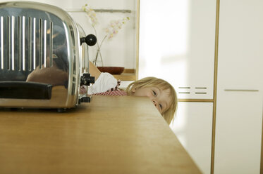 Girl (4-5) hiding behind kitchen worktop, close-up, portrait - WESTF02133