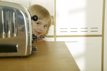 Girl (4-5) behind toaster in kitchen, close-up, portrait - WESTF02130