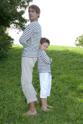 Vater und Sohn (4-7) stehen im Park, Rücken an Rücken - WESTF02313