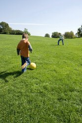 Vater und Sohn (4-7) spielen Fußball im Park - WESTF02294