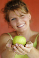 Woman holding an apple, close-up - CRF01000