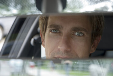 Businessman looking into rear view mirror, close-up - WESTF02461