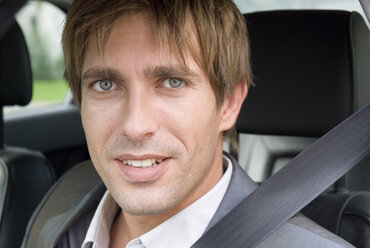 Young man sitting in car, portrait - WESTF02442