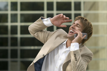 Businessman using mobile phone, laughing, close-up - WESTF02429