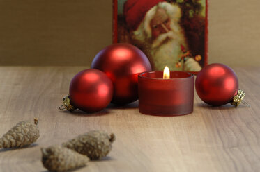 Weihnachtsdekoration mit brennender Kerze und Christbaumkugeln - ASF02520