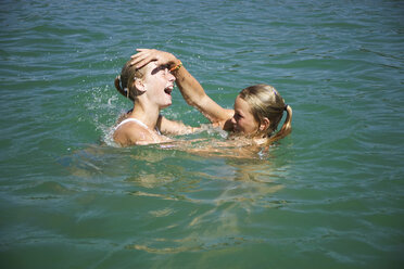 Teenager-Mädchen (13-15) spielen im Wasser, Seitenansicht - WESTF01713
