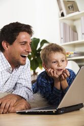 Vater und Sohn (6-7) benutzen einen Laptop - RDF00148