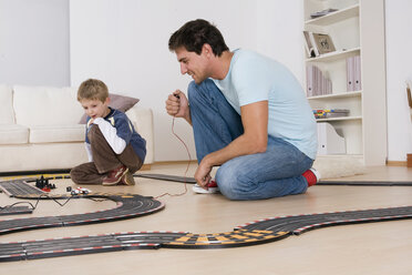 Vater und Sohn (6-7) spielen mit einer Spielzeugrennbahn - RDF00143
