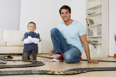 Vater und Sohn (6-7) spielen mit einer Spielzeugrennbahn - RDF00142