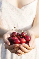 Woman holding cherries, close-up - NDF00049