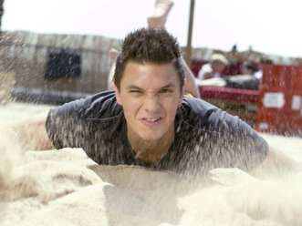 Junger Mann wirft Sand, unscharfe Bewegung - KMF00358