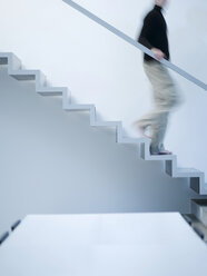 Man moving down stairs, side view - KM00499