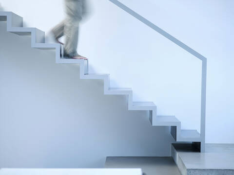 Mann geht eine Treppe hinunter, Seitenansicht, lizenzfreies Stockfoto