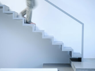 Man moving down stairs, side view - KM00491