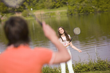 Junges Paar spielt Badminton, Fokus auf Frau - KMF00241