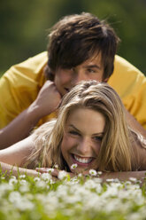 Junges Paar auf der Wiese liegend, lächelnd - KMF00216