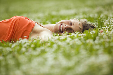 Teenage girl lying in meadow - KMF00211