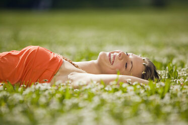 Teenage girl lying in meadow - KMF00210