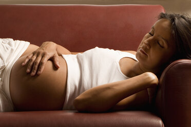 Pregnant woman lying on sofa, eyes closed - LDF00286