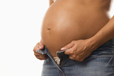 Pregnant woman putting on trousers, midsection - LDF00278