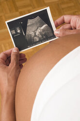 Pregnant woman holding ultrasonic picture, elevated view - LDF00273