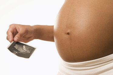 Pregnant woman holding ultrasonic picture, midsection - LDF00272