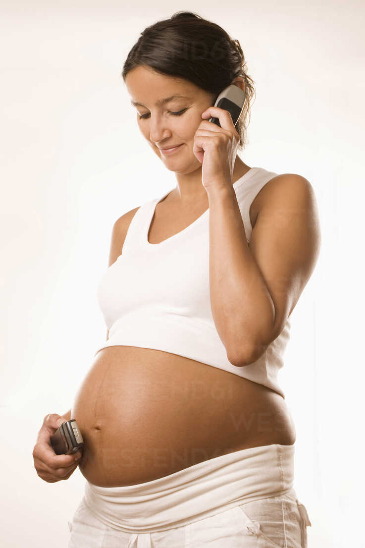 Mid-section of pregnant woman holding headphones at her belly stock photo