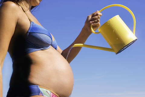 Pregnant woman, pouring belly, midsection, side view stock photo