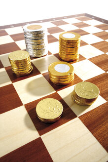 Schokolade und Geldmünzen auf einem Schachbrett - 05213CS-U