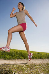 Young woman jogging, low angle view - WESTF02600