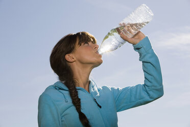 Junge Frau trinkt aus einer Wasserflasche - WESTF02545