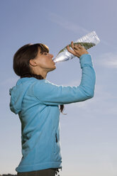 Junge Frau trinkt aus einer Wasserflasche - WESTF02544